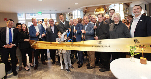 a group of people standing together and cutting a ribbon