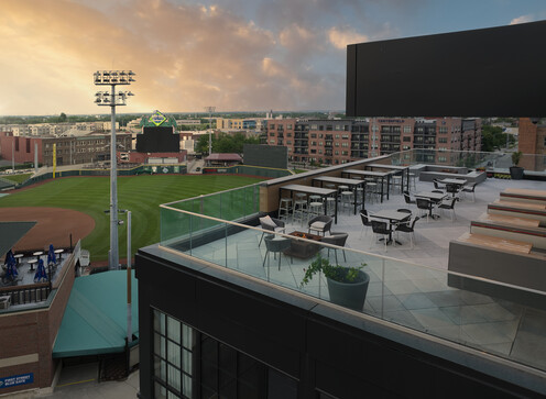 a rooftop patio with tables and chairs on a baseball field