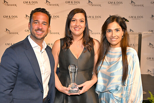 three people standing with award