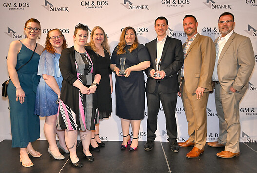 group of people gather with awards