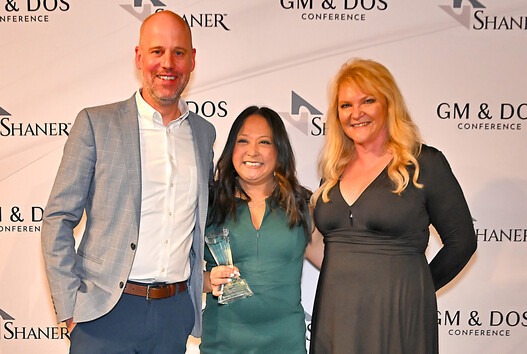 three people celebrate winning award