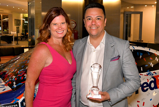 two people pose with award