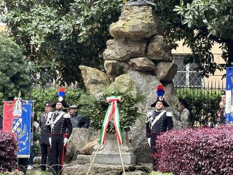 a group of people in uniform standing in front of a statue