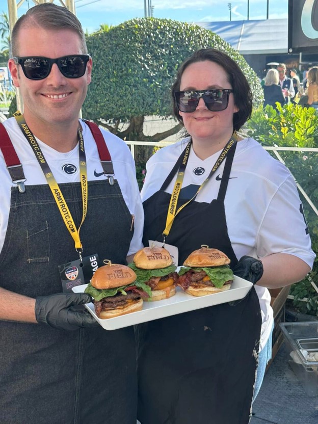 Chef and Sous Chef holding a tray of three burgers at the Orange Bowl Burger Battle